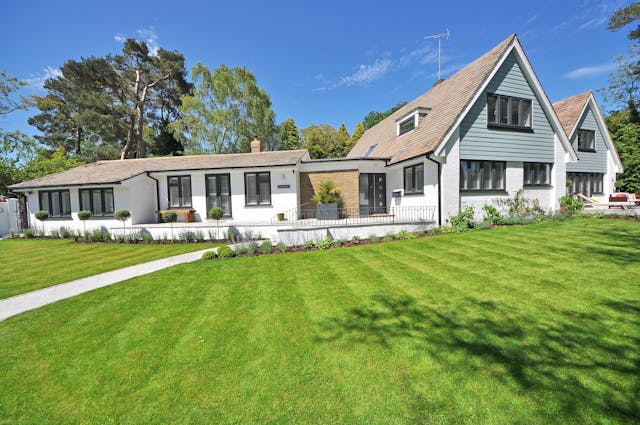 A white suburban home with a front yard.