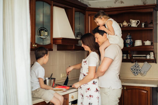 A woman cooking with her husband and two kids.